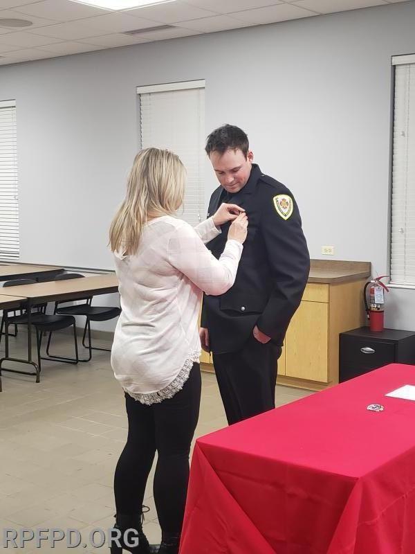 FF/PM James Evans' mother, Rhonda Evans, pins his badge on during the Swearing-In ceremony. 12/10/2019